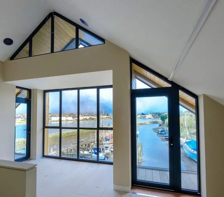 2 gable end windows and an aluminium casement door leading to and external balcony protected by a frameless glass balustrade