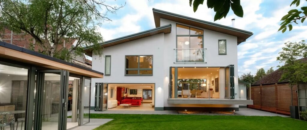 a luxury new build home with a modern juliet balcony aluminium bifold doors and aluminium casement windows with grey frames