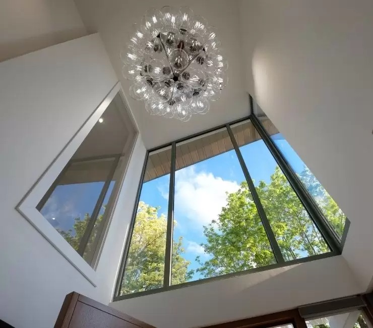 double height entrance way with fixed glazing and a unqiue light fixture to create a well lit inviting and modern home entrance.jpg